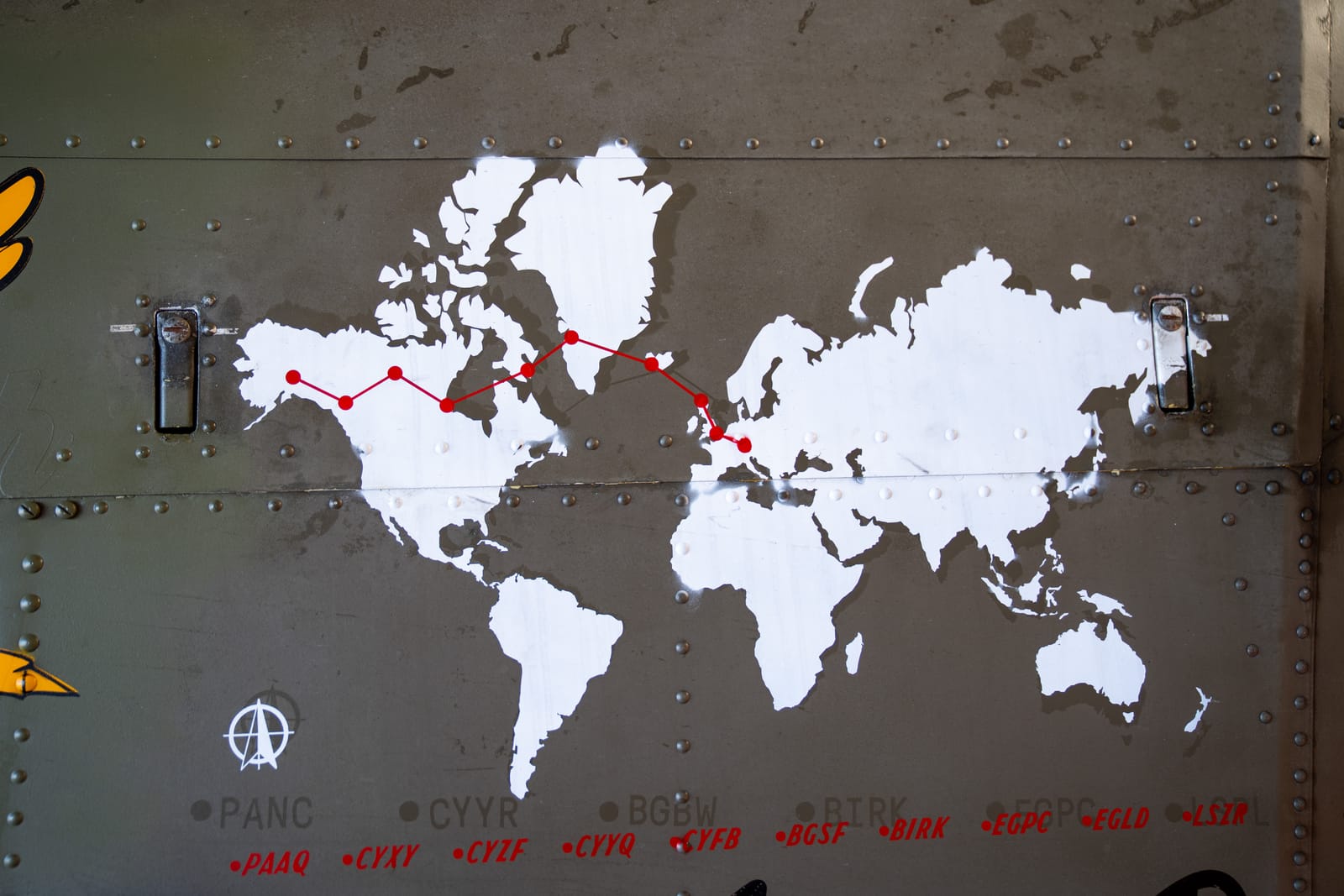 Weltkarte auf dem Rumpf mit der eingezeichneten Route von Alaska in die Schweiz.